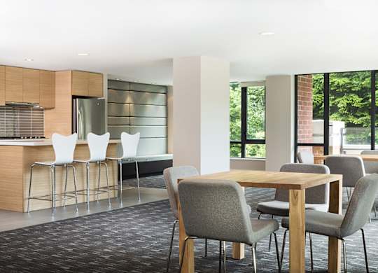 A modern dining area with a wooden table and grey chairs.