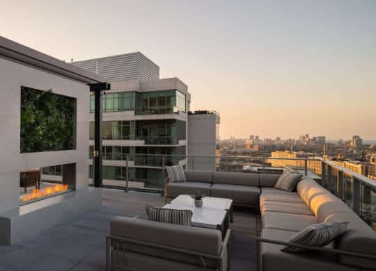 a terrace with couches and a table with chairs and a fireplace