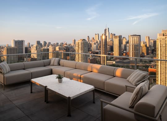 a terrace with a couch and a table overlooking a city