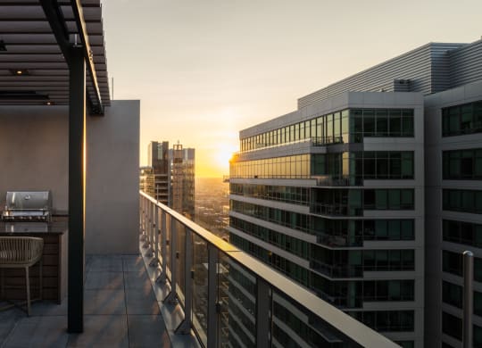 a balcony with a view of the city at sunset