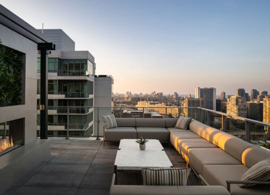 a terrace with couches and a table with a potted plant