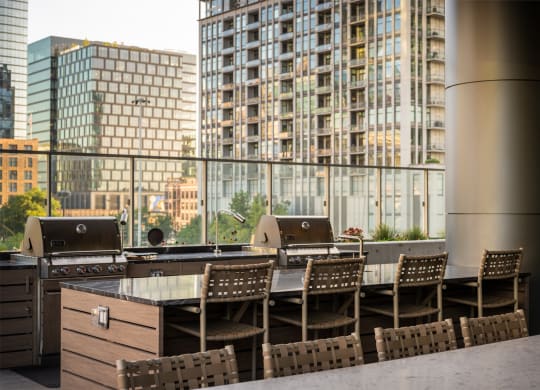 a table with chairs in front of a large window with a city in the background