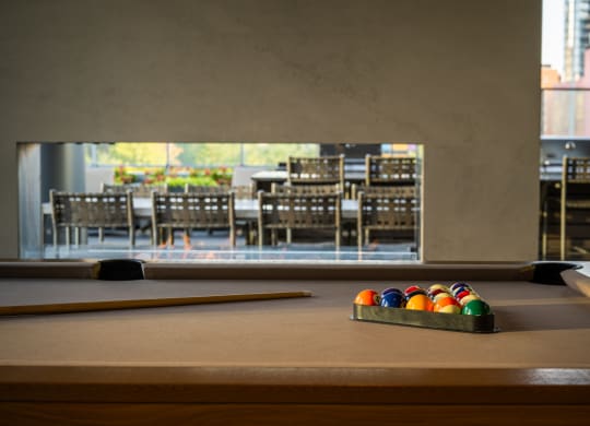a pool table with a view of a dining room in the background