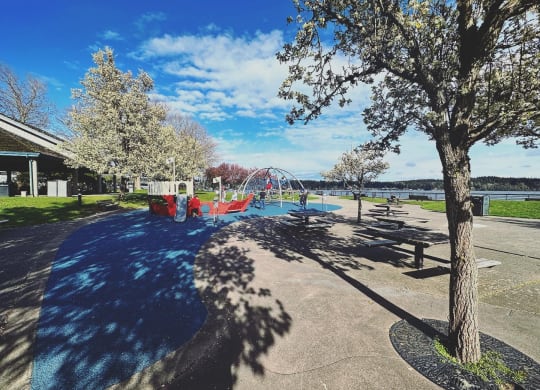 a park with a playground and a lake in the background at Rivulet, Silverdale, 98383