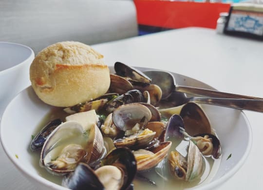 a bowl of clams and mussels with a roll on the side at Rivulet, Silverdale, WA