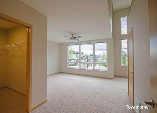 A room with a carpet floor and a ceiling fan at Spyglass Hill Apartments, Bremerton, Washington