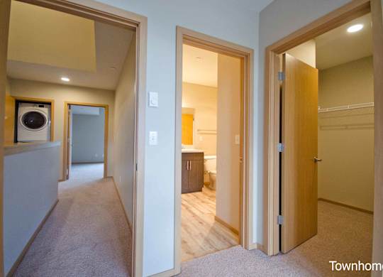 A hallway with a washer and dryer in a home at Spyglass Hill Apartments, Bremerton