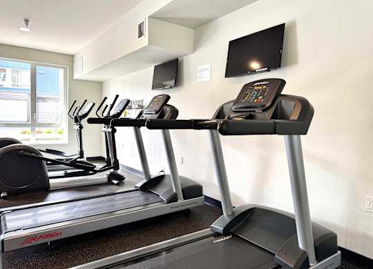 A treadmill with a LG brand logo is in a gym.
