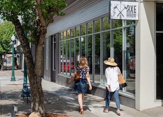 Two women walking past a storefront with a sign that read at B Flats Apartments, Bremerton, 98337
