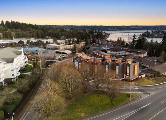 A road with a curve and a building on the side. at The Narrows at Clare Apartments , Washington, 98310