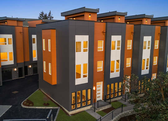 A modern apartment complex with a mix of grey and orange exterior. at The Narrows at Clare Apartments , Bremerton, Washington