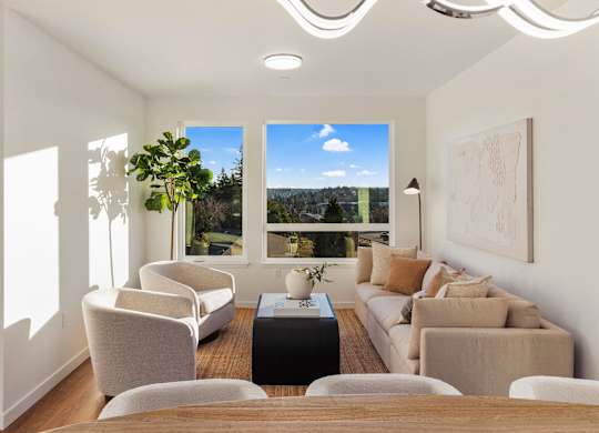 A living room with a large window overlooking a landscape. at The Narrows at Clare Apartments , Bremerton, 98310