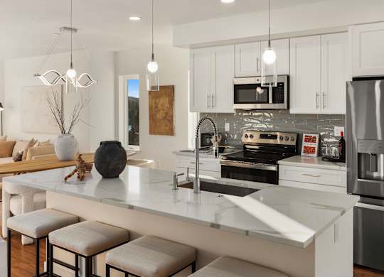 A modern kitchen with a white island and stainless steel appliances. at The Narrows at Clare Apartments , Bremerton
