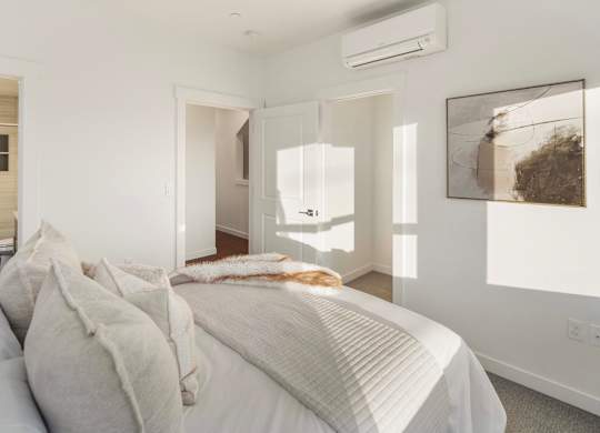 A bedroom with a large bed and a painting on the wall. at The Narrows at Clare Apartments , Washington