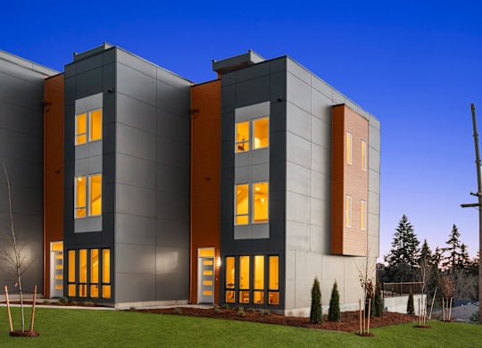 A modern building with a grey facade and orange accents at The Narrows at Clare Apartments , Washington