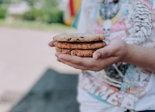 a boy in a colorful shirt holding a stack of cookies at Rivulet, Silverdale, Washington
