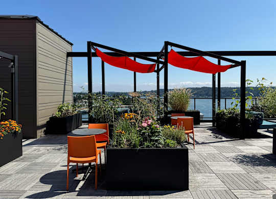 a rooftop terrace with orange chairs and tables at Spyglass Hill Apartments, Washington 98337