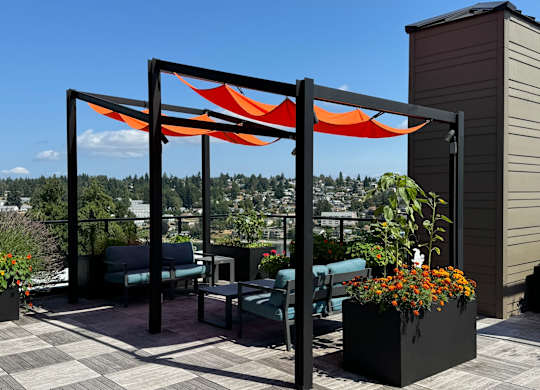 a patio with a canopy and chairs on a roof at Spyglass Hill Apartments, Bremerton, Washington