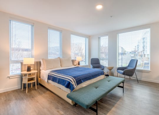 a bedroom with a bed and three oversized windows at Marina Square, Bremerton