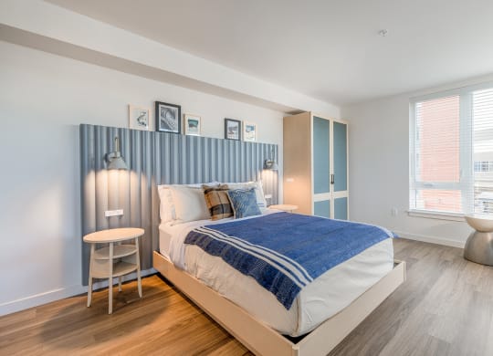a bedroom with a bed and a chair in front of a window at Marina Square, Washington