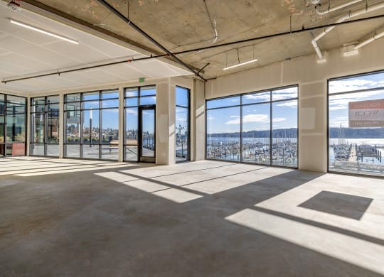 an empty room with floor to ceiling windows and a view of the water at Marina Square, Bremerton