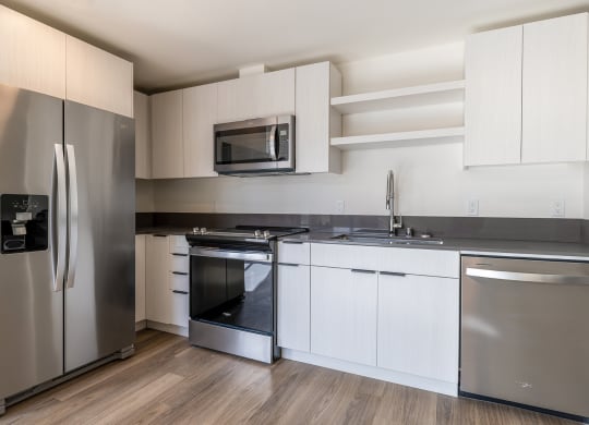 a kitchen with white cabinets and stainless steel appliances at Marina Square, WA 98337