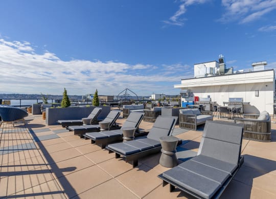 a roof top deck with lounge chairs and a barbecue at Marina Square, WA 98337