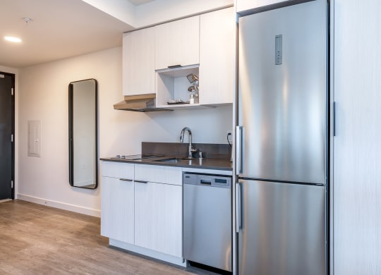 a small kitchen with white cabinets and stainless steel appliances at Marina Square, Bremerton, Washington 98337