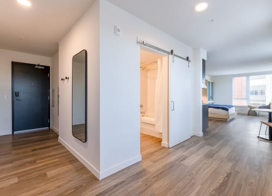 a bedroom with white walls and hardwood floors at Marina Square, Bremerton, 98337