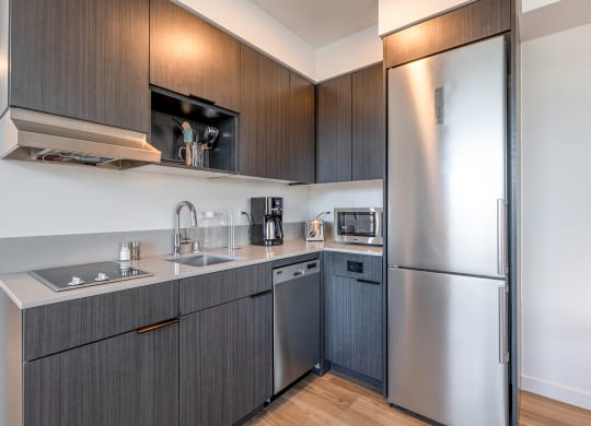 a modern kitchen with dark cabinets and stainless steel appliances at Marina Square, Bremerton, 98337