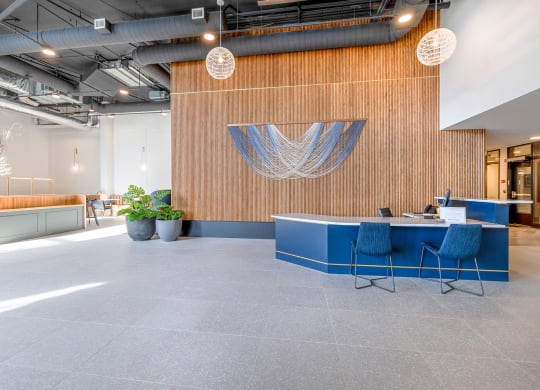 a large open office space with a wooden wall and a blue desk with blue chairs at Marina Square, Bremerton, WA