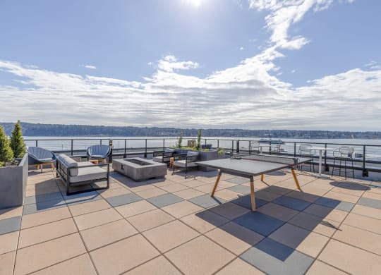 a large terrace with a ping pong  at Marina Square, Bremerton, WAtable and a view of the water
