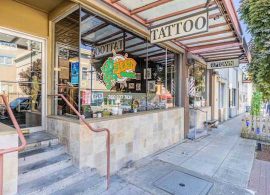 A tattoo shop with a red staircase leading to the entrance.