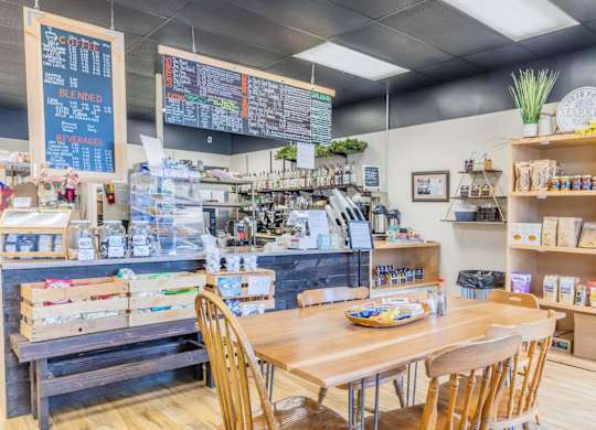 A coffee shop with a wooden table and chairs in the foreground.