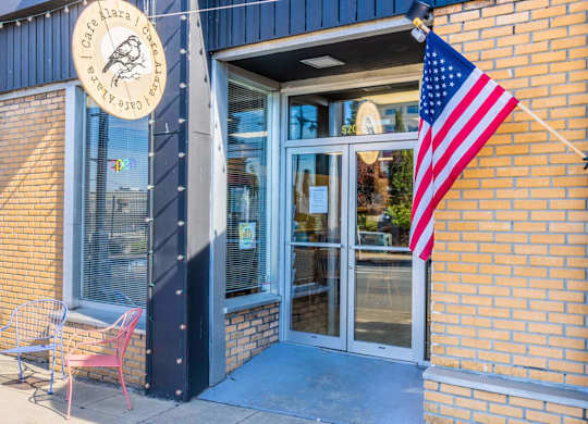 A building with a sign that says Cafe Mara and an American flag hanging outside.