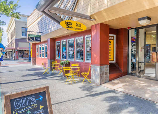 A storefront with a yellow chair outside and a sign that says