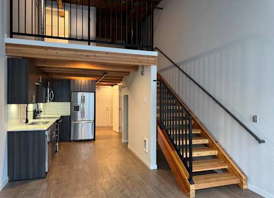 A modern kitchen with a staircase leading to the upper floor at B Flats Apartments, Bremerton, Washington