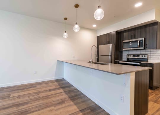 a kitchen with an island and a stove and a refrigerator at Rivulet, Silverdale, 98383