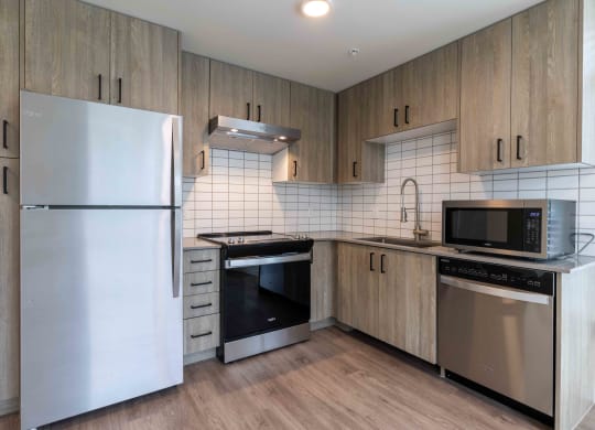 a kitchen with stainless steel appliances and wooden cabinets at Rivulet, Silverdale, 98383