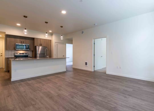 an empty living room with a kitchen and a counter top at Rivulet, Washington, 98383
