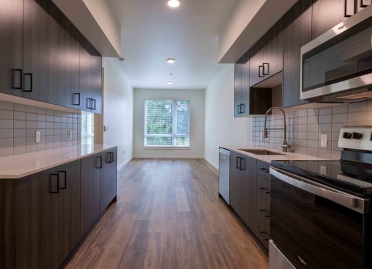 a kitchen with wooden floors and dark cabinets at Rivulet, Washington, 98383