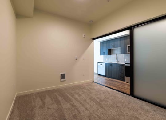 a room with a door to the kitchen and carpeted flooring at Rivulet, Washington
