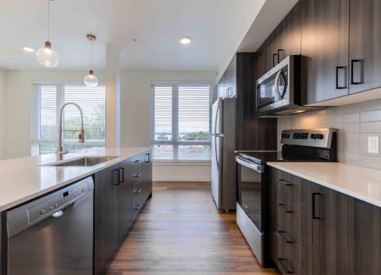 a large kitchen with stainless steel appliances and wooden cabinets  at Rivulet, Silverdale, Washington