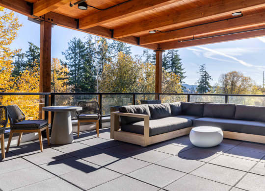 a patio with a couch and tables on a roof at Rivulet, Silverdale, WA