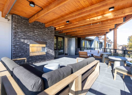 a patio with couches and tables and a fireplace at Rivulet, Silverdale, 98383