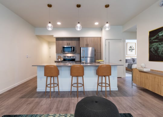 a kitchen with a bar and stools in a living room with a kitchen island at Rivulet, Washington