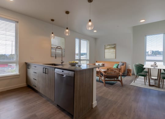 a kitchen with an island and a living room with a table and chairs at Rivulet, Silverdale, WA