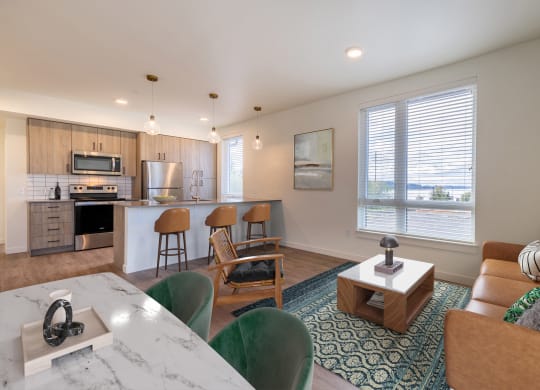 an open living room and kitchen with a table and chairs at Rivulet, Silverdale, WA