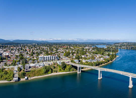 a bridge over a body of water with a city in the background and a river at Spyglass Hill Apartments, Washington