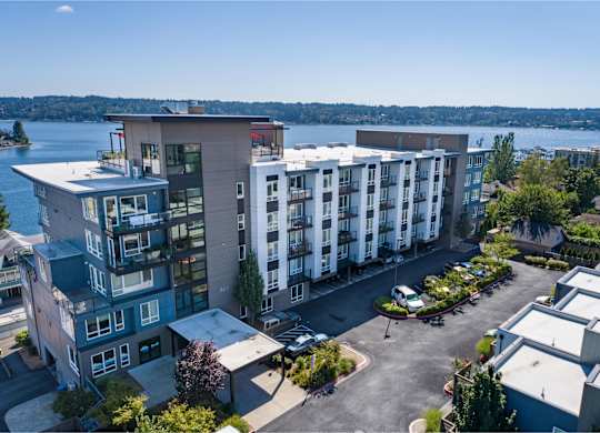 an aerial view of an apartment building with a lake in the background at Spyglass Hill Apartments, Washington 98337